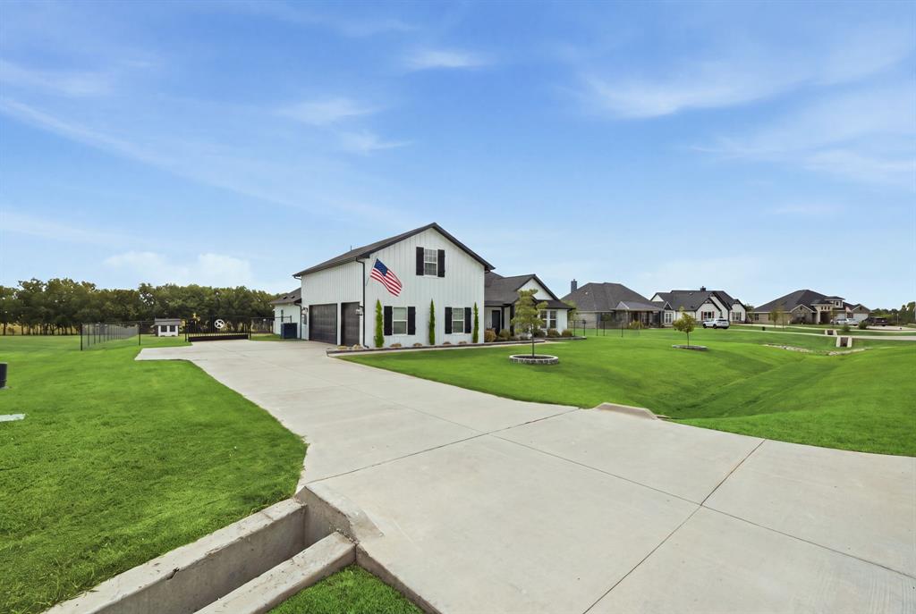 10216 Finch Road Sanger, TX 76266 - Photo 3 of 40 White exterior with black trim, concrete driveway, attached garage, and expansive green lawn - Virtual Grass