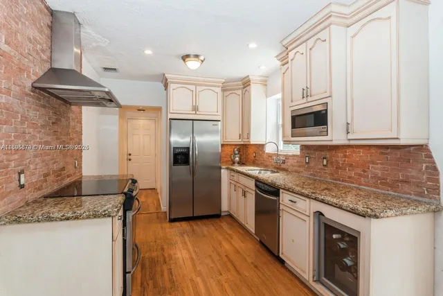 a kitchen with stainless steel appliances granite countertop a stove a refrigerator and a microwave
