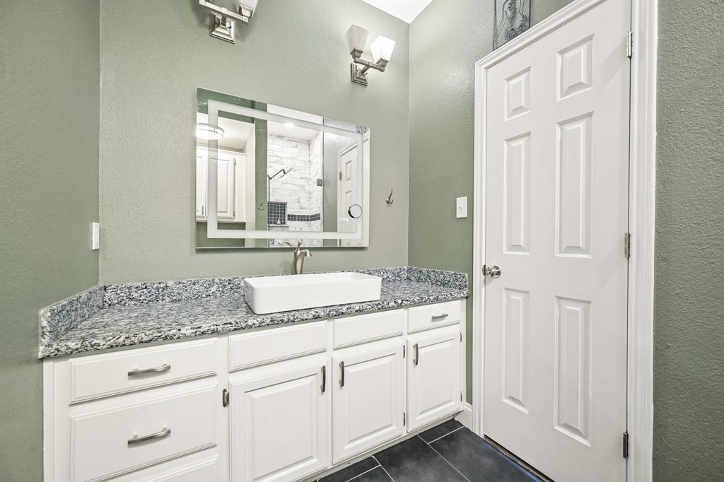 1380 Meandro Ria Lane Fairview, TX 75069 - Photo 25 of 39 White vanity with ample cabinetry, granite countertop, rectangular vessel sink, and an illuminated mirror
