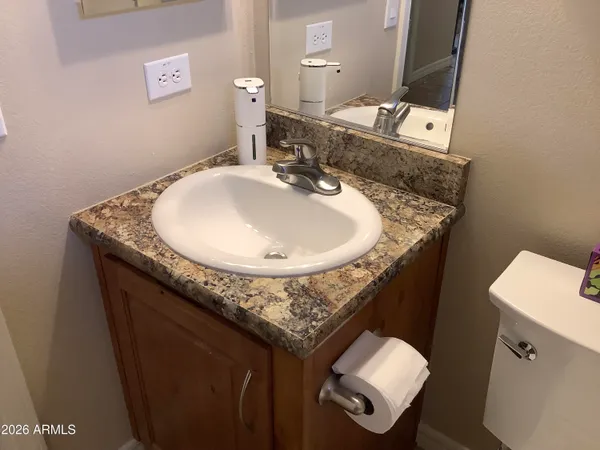 a bathroom with a granite countertop sink a toilet and mirror