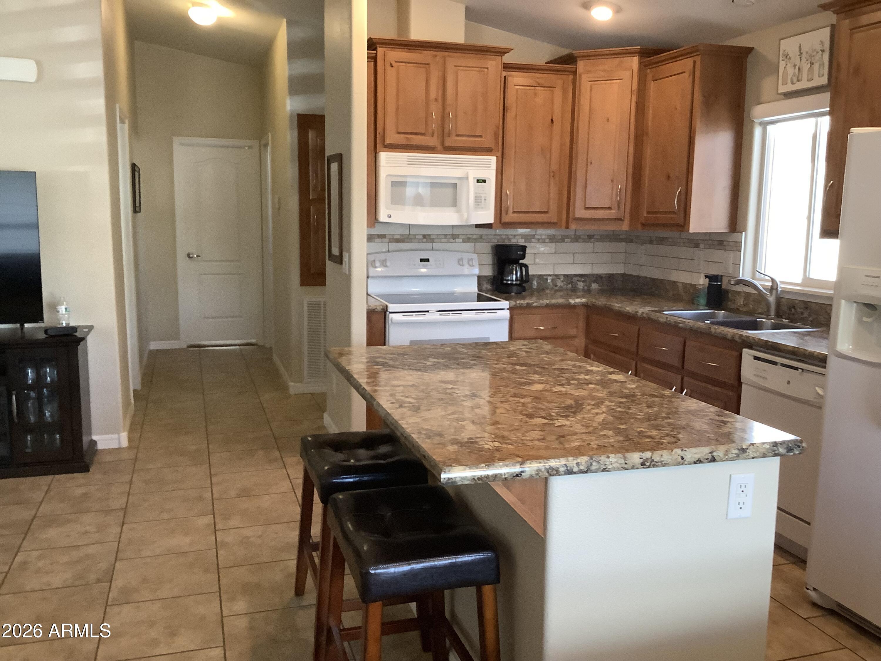 650 North Hawes Road, Unit 4007 Mesa, AZ 85207 - Photo 24 of 42 a kitchen with stainless steel appliances granite countertop a stove a sink and a microwave