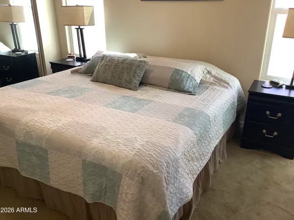 a large bed sitting in a bedroom next to a window