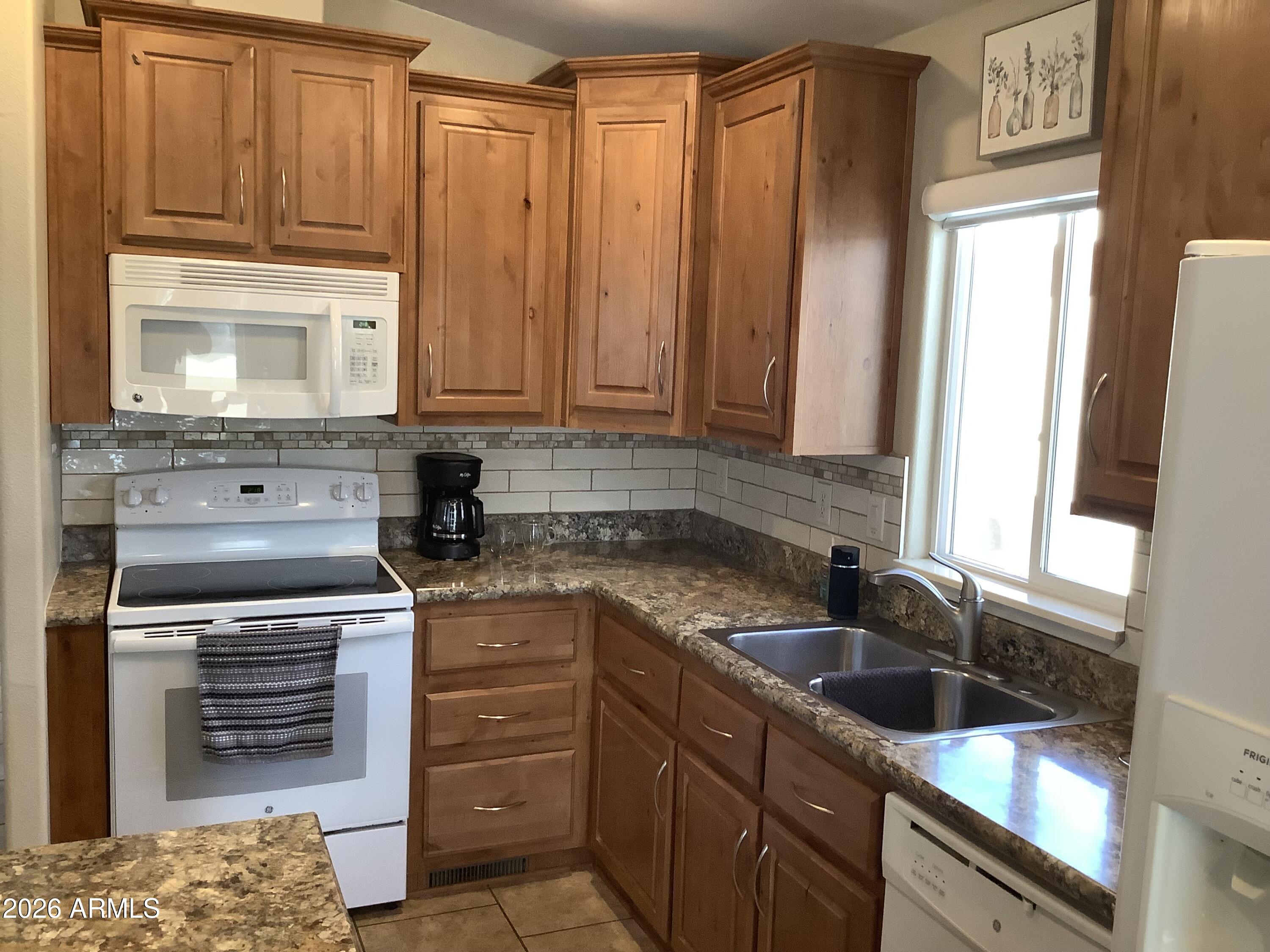 650 North Hawes Road, Unit 4007 Mesa, AZ 85207 - Photo 8 of 42 a kitchen with stainless steel appliances granite countertop a sink stove and refrigerator