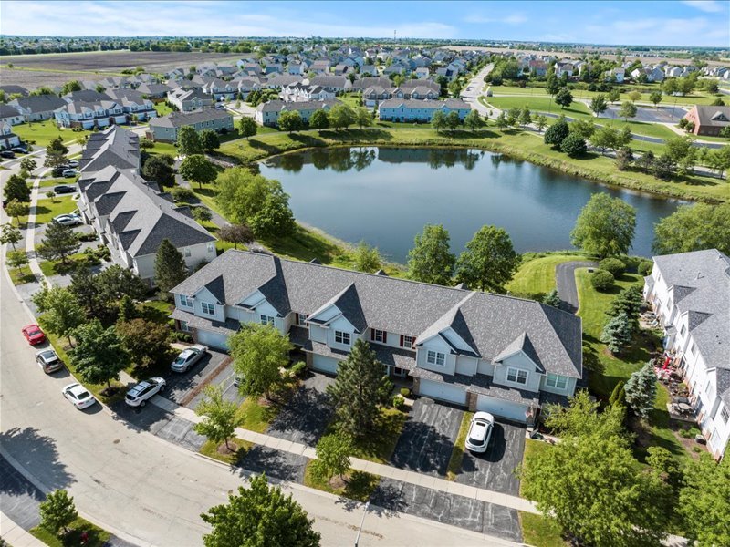 an aerial view of house with yard space and lake view in back