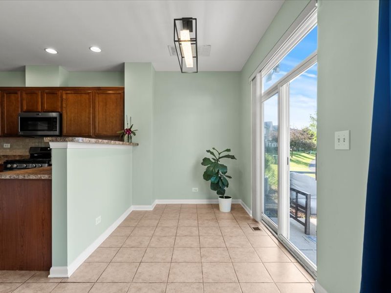 2147 Pembridge Lane Joliet, IL 60431 - Photo 11 of 34 a hallway with a dining table and a potted plant