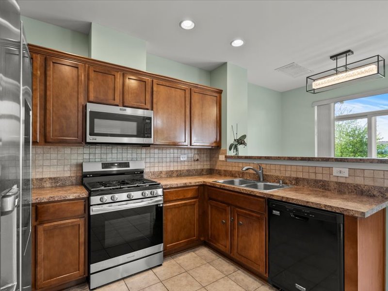 2147 Pembridge Lane Joliet, IL 60431 - Photo 12 of 34 a kitchen with a sink stove and microwave
