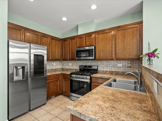a kitchen with a sink a refrigerator and cabinets