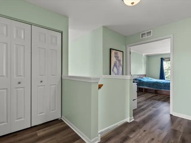 a view of a room that has a bed and a mirror in it