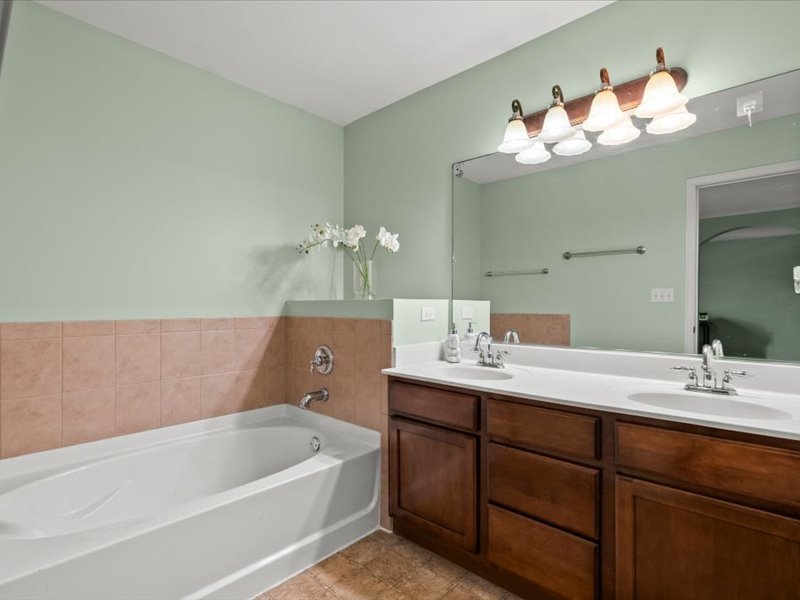 2147 Pembridge Lane Joliet, IL 60431 - Photo 19 of 34 a bathroom with a tub a double vanity sink and a mirror
