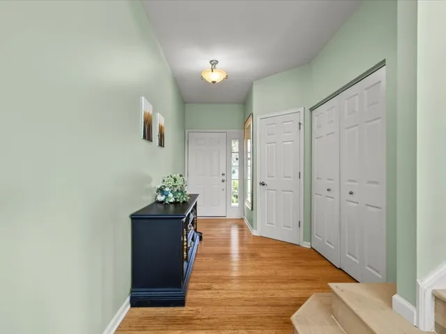 a view of a hallway with wooden floor and a bathroom