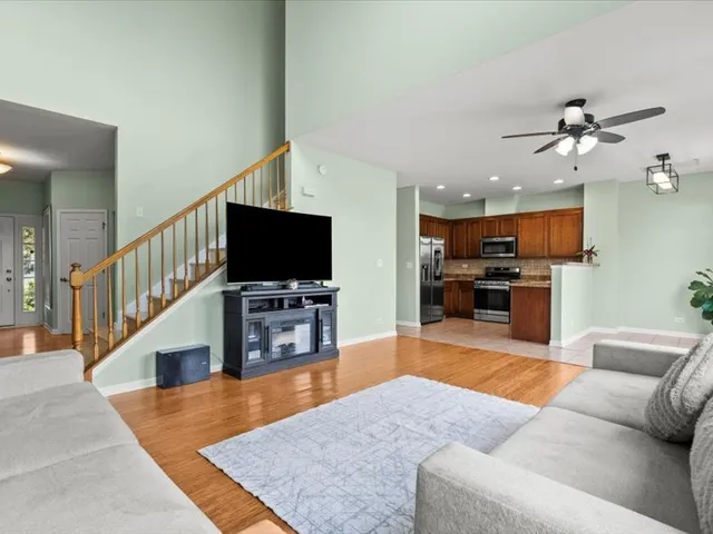 a living room with furniture kitchen view and a flat screen tv