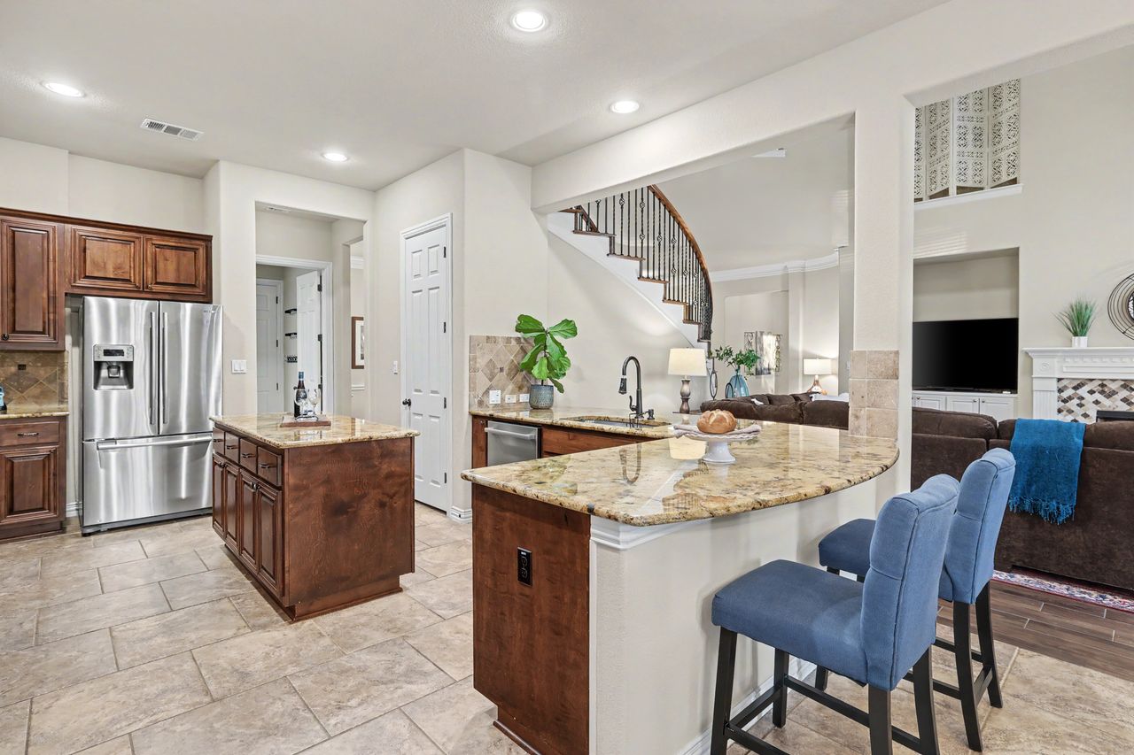 2828 Collingwood Drive Round Rock, TX 78665 - Photo 13 of 38 a kitchen with stainless steel appliances granite countertop a table chairs and a refrigerator