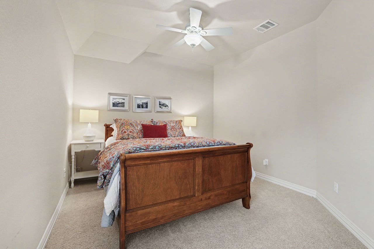 2828 Collingwood Drive Round Rock, TX 78665 - Photo 22 of 38 a bed sitting in a bedroom next to a window with a chandelier