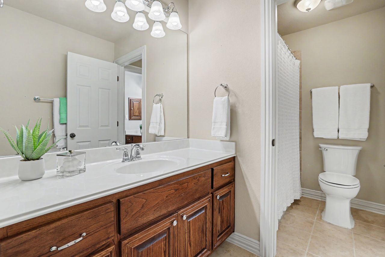 2828 Collingwood Drive Round Rock, TX 78665 - Photo 25 of 38 a bathroom with a sink a toilet and a mirror
