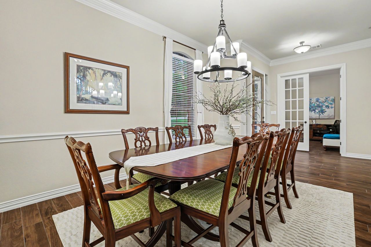 2828 Collingwood Drive Round Rock, TX 78665 - Photo 7 of 38 a dining room with furniture a chandelier and wooden floor