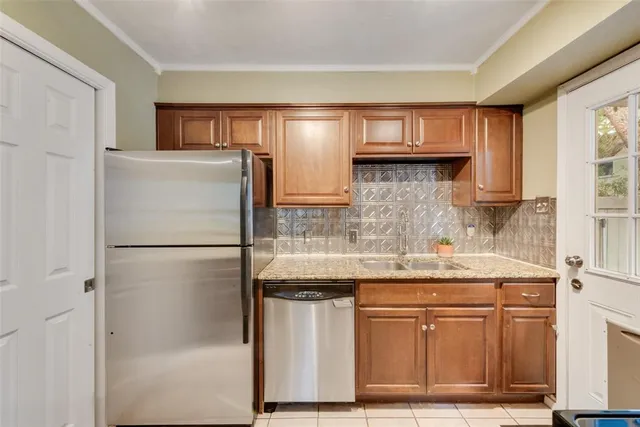 a kitchen with stainless steel appliances granite countertop a refrigerator and a sink