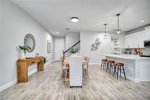 an open kitchen with dining table and stainless steel appliances