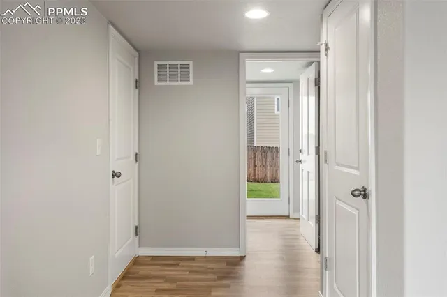 a view of a hallway with wooden floor