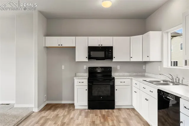 a kitchen with a refrigerator stove and white cabinets