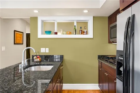 a kitchen with stainless steel appliances granite countertop a sink stove and refrigerator