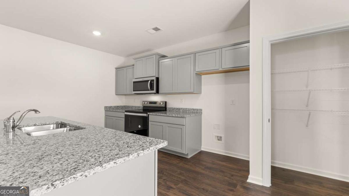 8576 Seabiscuit Road Lithonia, GA 30058 - Photo 12 of 22 a kitchen with a refrigerator stove and sink