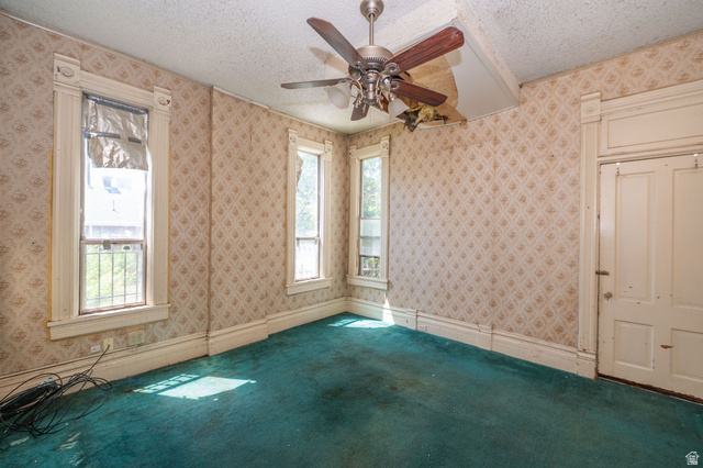 1256 24th Street Ogden, UT 84401 - Photo 15 of 34 Room featuring patterned wallpaper, a ceiling fan with wood-finish blades, and teal carpeting