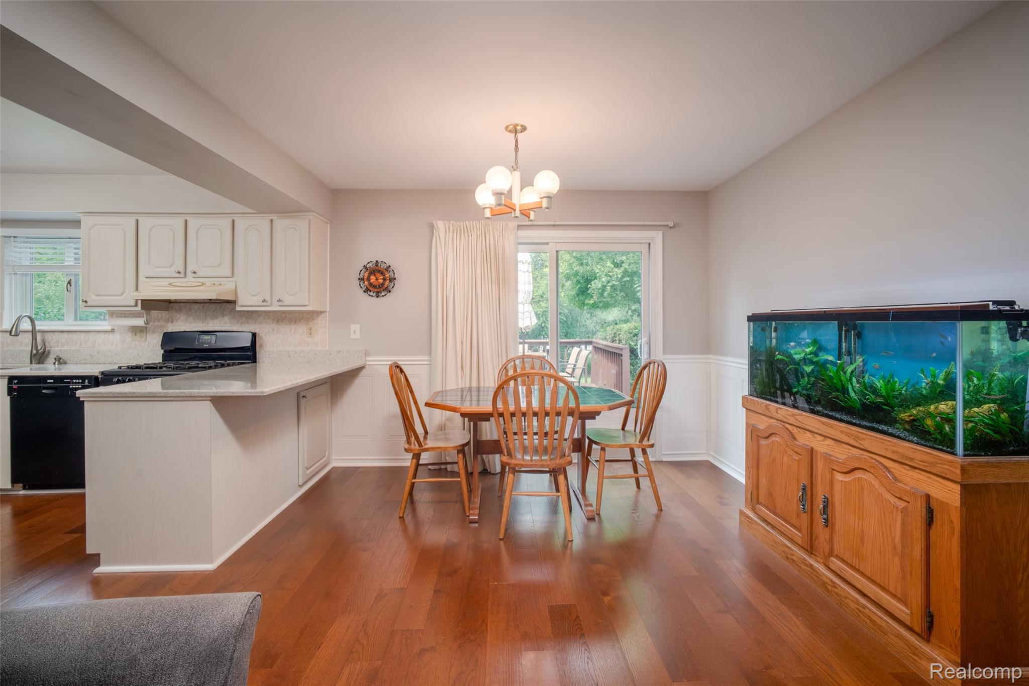 22533 Winfield Road Novi, MI 48375 - Photo 10 of 43 Open-concept dining area with wood-finish flooring, white wainscoting, and a sliding glass door