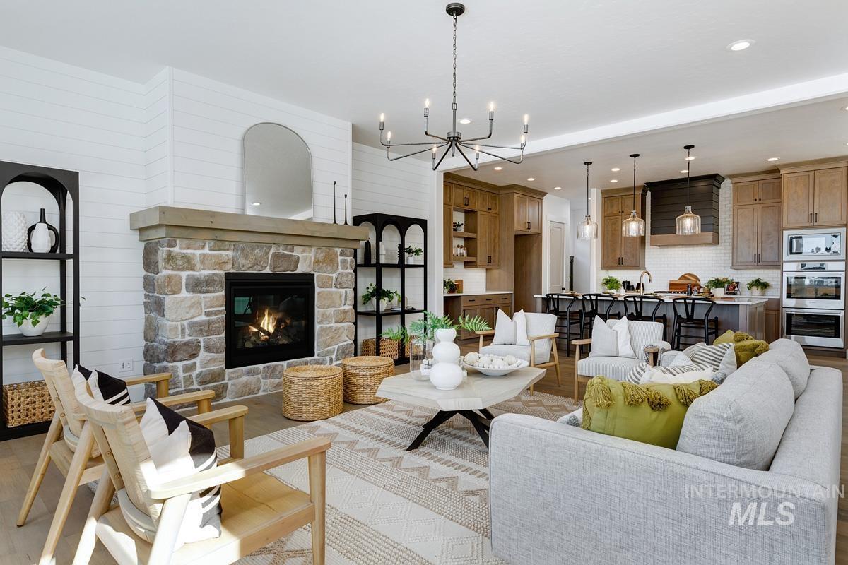 21913 Paint Avenue Star, ID 83669 - Photo 5 of 45 Living room featuring a fireplace, a chandelier, recessed lighting, wooden walls, and wood finished floors