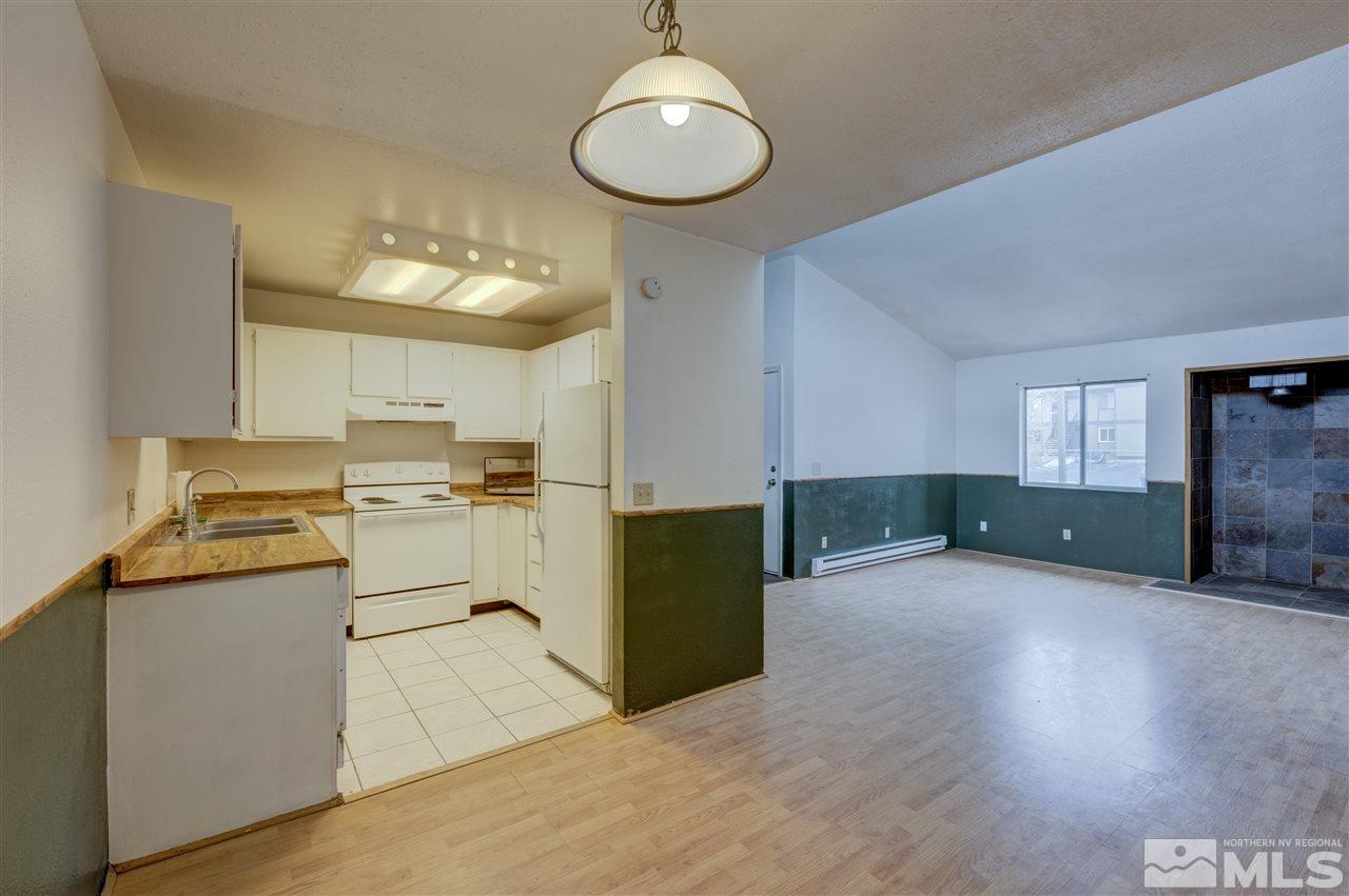 2101 Highview Court, Unit 14 Reno, NV 89512 - Photo 5 of 16 a kitchen with a refrigerator a sink dishwasher with a dining table and chairs