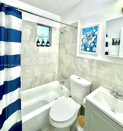 a white toilet sitting next to a bathroom sink and a tub