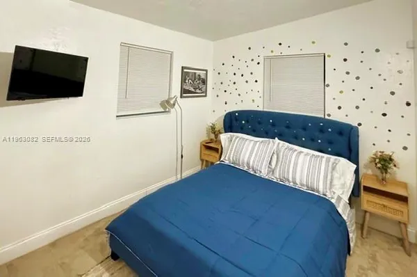 a bedroom with a bed and flat screen tv