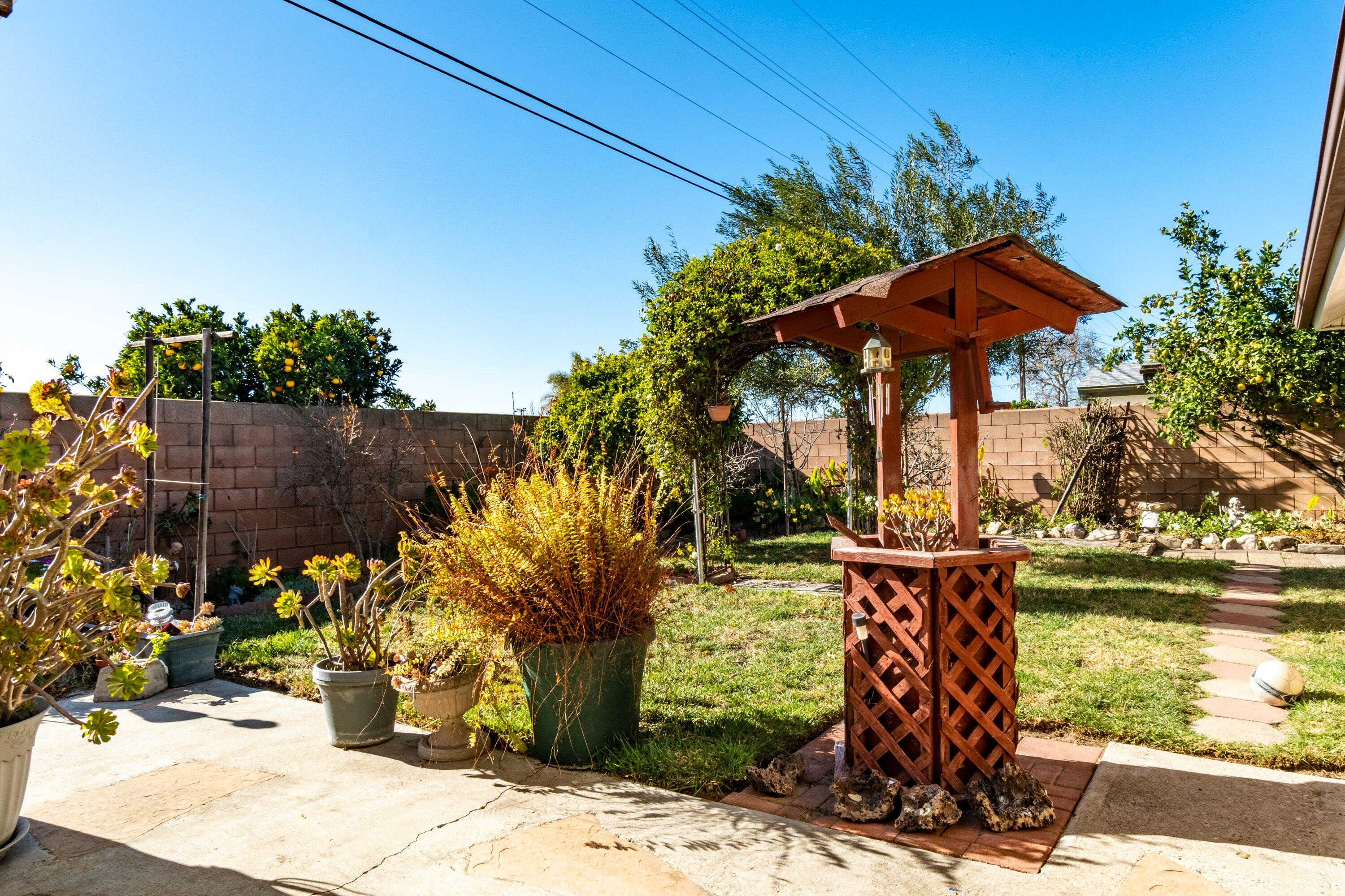 4076 Constellation Road Lompoc, CA 93436 - Photo 20 of 21 a view of a garden with a bench under an umbrella
