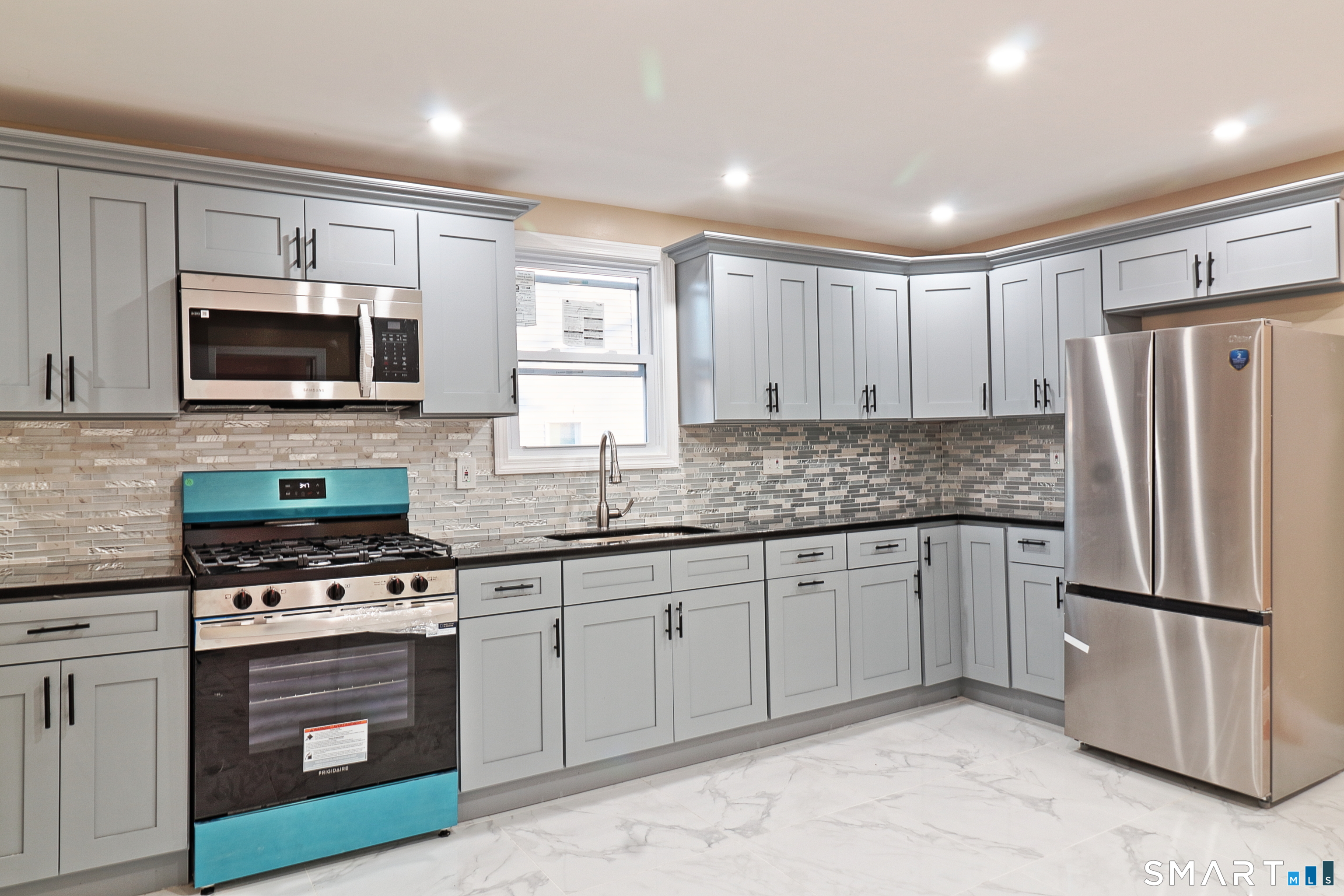 40 Elizabeth Street, Unit 2 Waterbury, CT 06704 - Photo 1 of 11 a kitchen with granite countertop a refrigerator stove and microwave