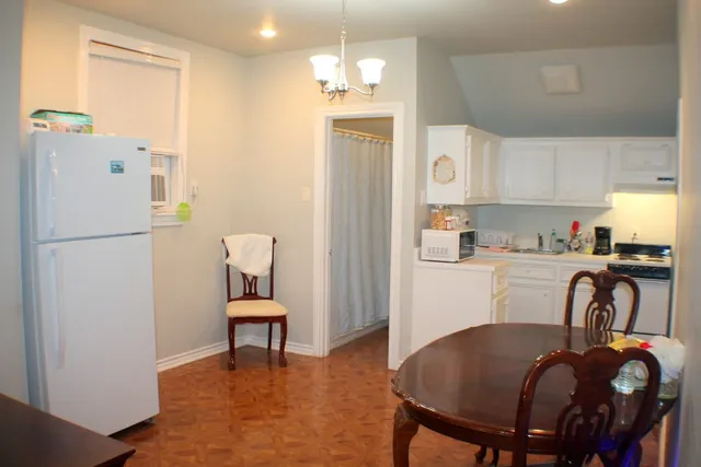 a kitchen with stainless steel appliances granite countertop a refrigerator and a dining table