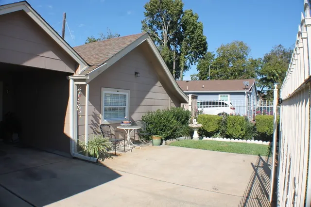 a front view of a house with a yard and potted plants