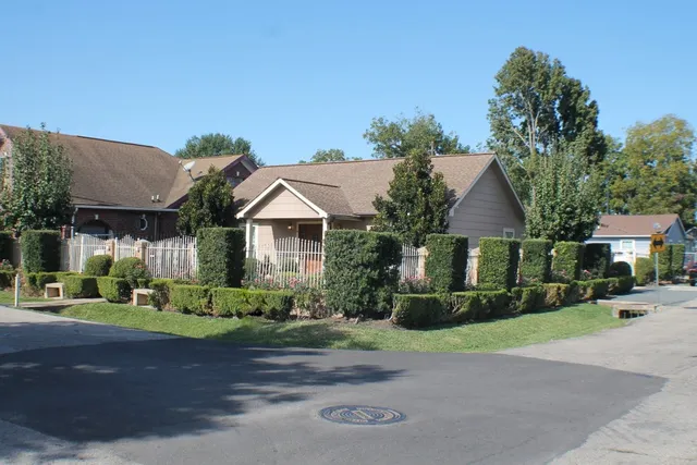 a front view of a house with a yard and trees