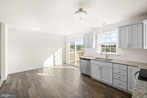 a large kitchen with a wooden floor and white cabinets