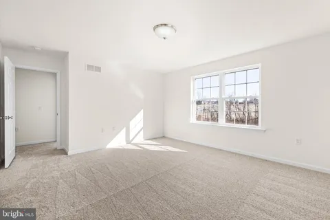 an empty room with windows and back yard