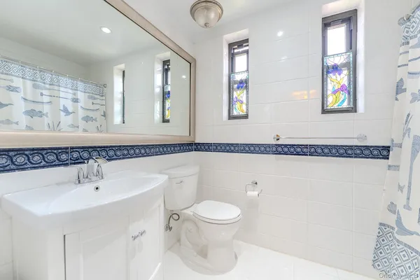 a bathroom with a toilet a sink and a mirror
