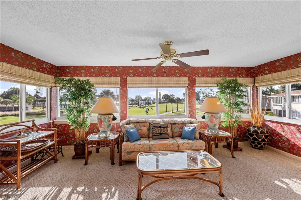 200 Albi Road, Unit 2 Naples, FL 34112 - Photo 13 of 49 a living room with furniture a chandelier and a large window
