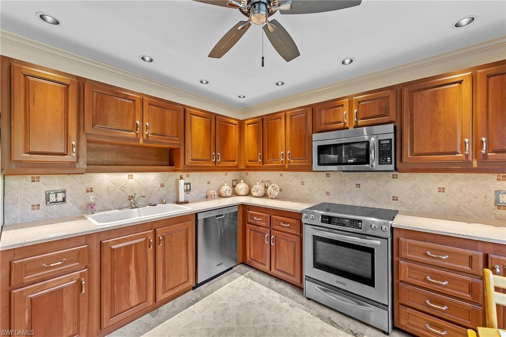 200 Albi Road, Unit 2 Naples, FL 34112 - Photo 19 of 49 a kitchen with stainless steel appliances granite countertop a sink stove and microwave