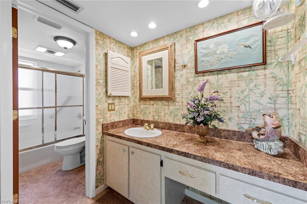 200 Albi Road, Unit 2 Naples, FL 34112 - Photo 30 of 49 a bathroom with a granite countertop sink mirror and toilet