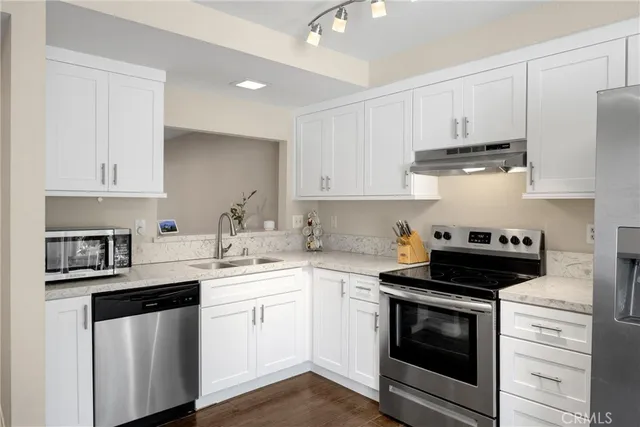 a kitchen with cabinets stainless steel appliances a sink and a counter space