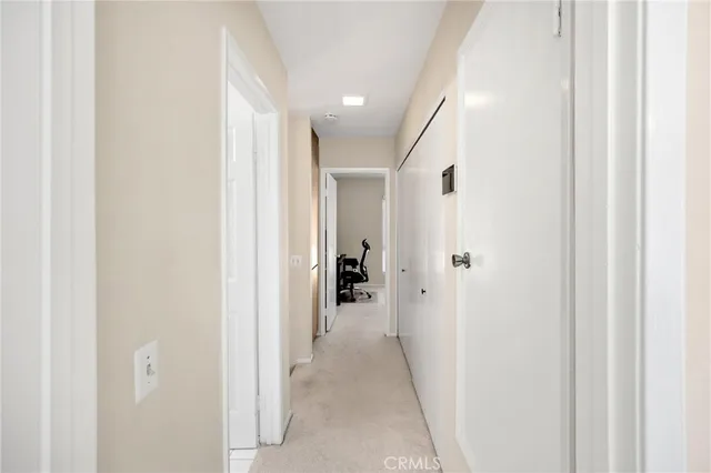 a view of a hallway with closet and a bathroom