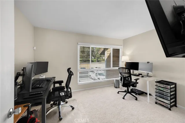 a view of a workspace with furniture and a window