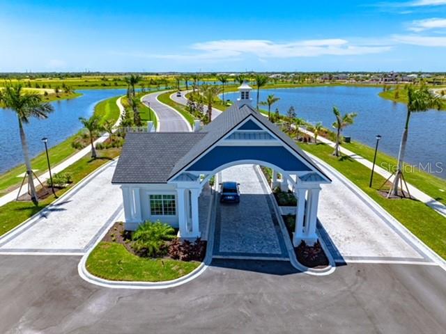 17595 Foxtail Loop Venice, FL 34293 - Photo 7 of 8 a front view of a house with a garden and lake view