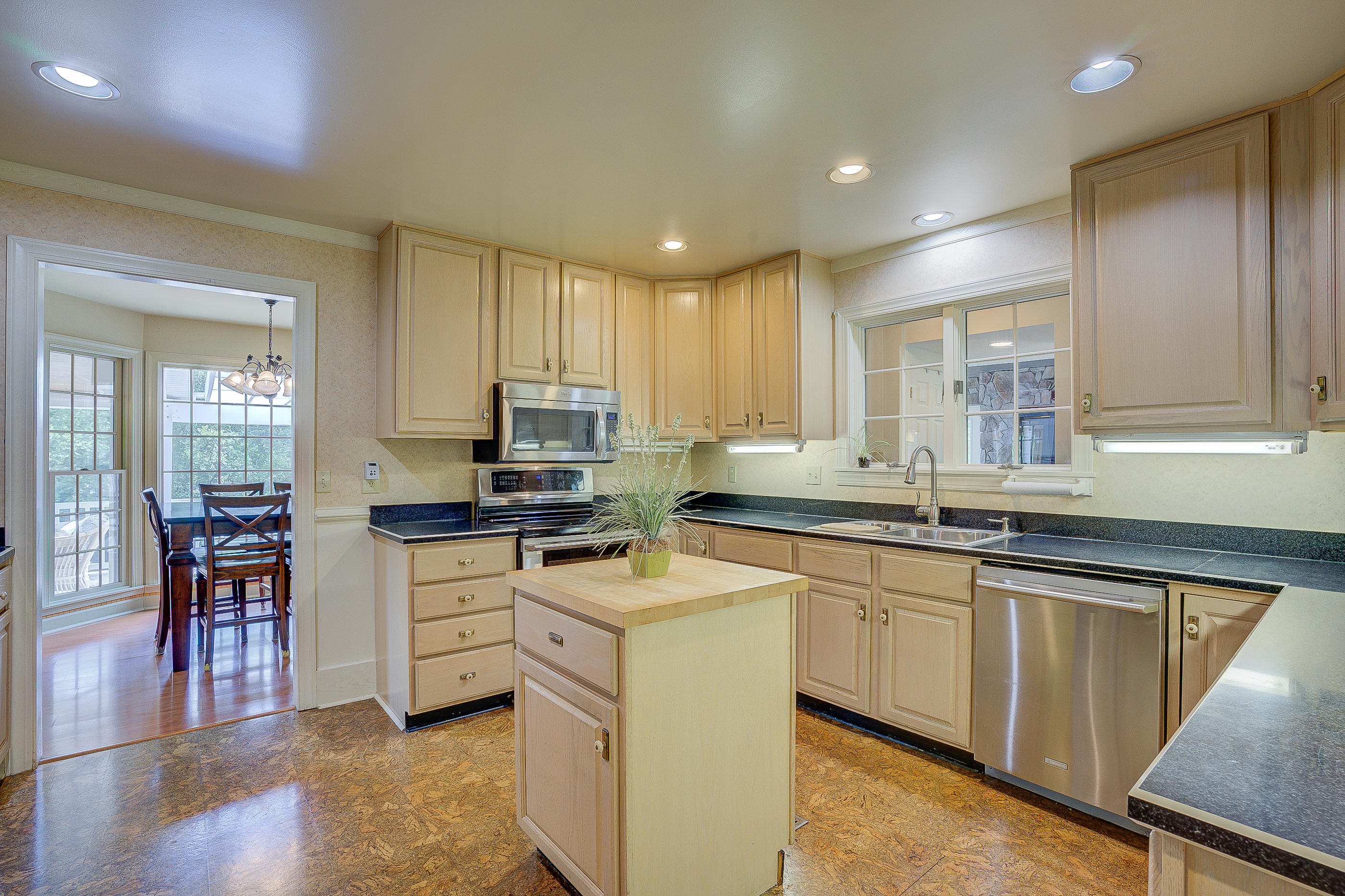 105 River Road North Covington, VA 24426 - Photo 14 of 77 a kitchen with stainless steel appliances granite countertop a stove top oven a sink dishwasher a dining table and chairs with wooden floor