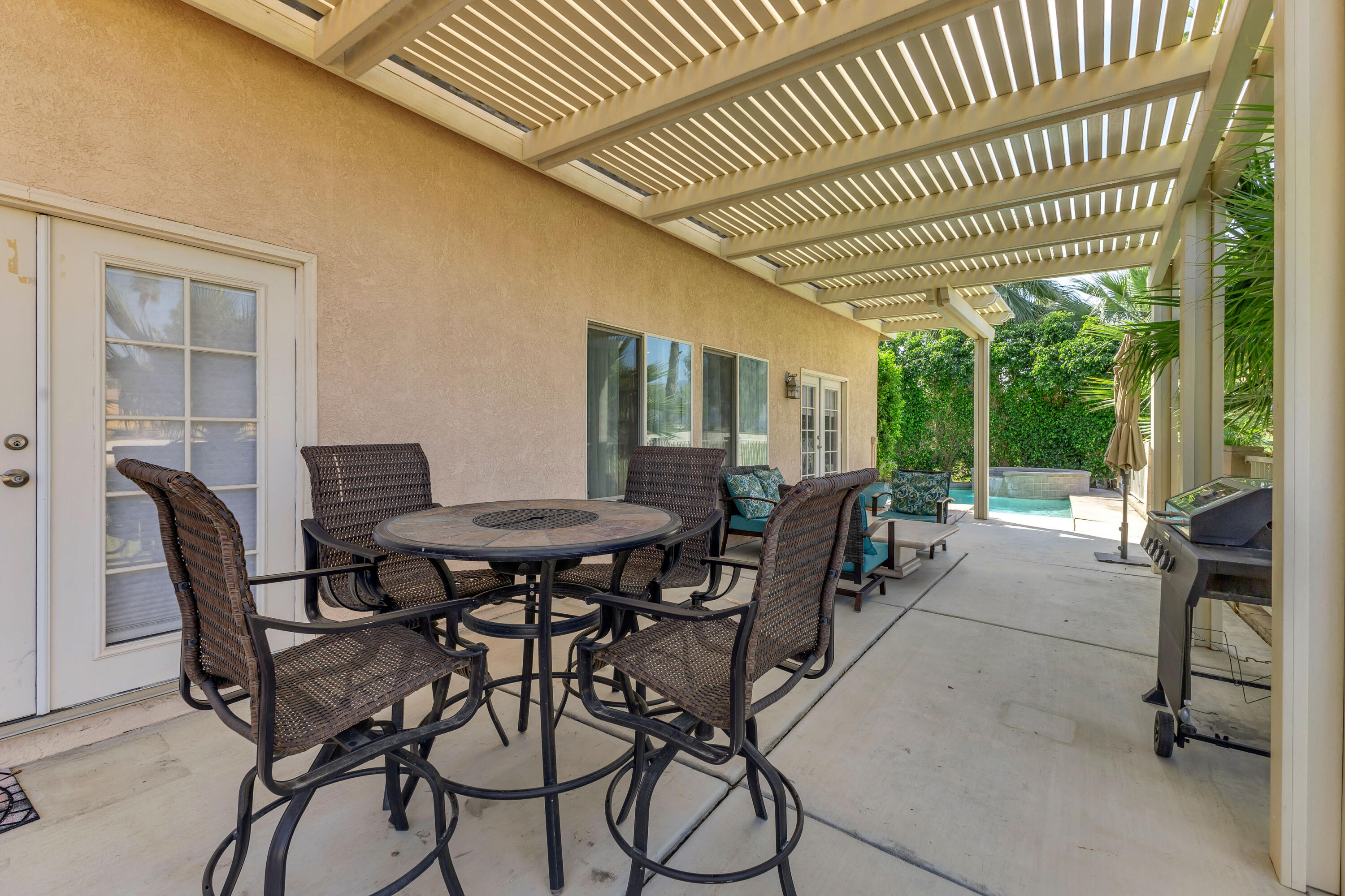 48305 Pic Way Indio, CA 92201 - Photo 59 of 77 a view of a patio with table and chairs and floor to ceiling window