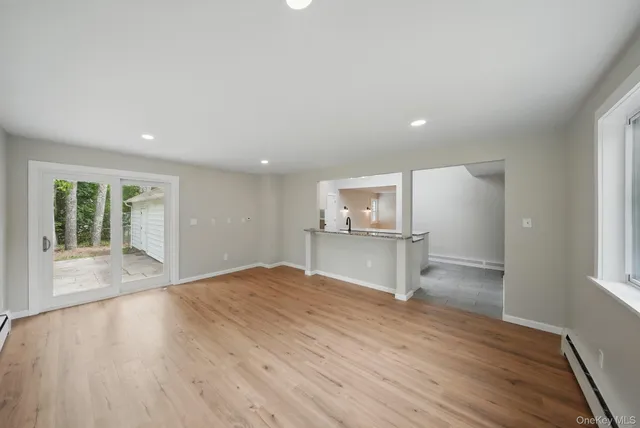 a view of empty room with wooden floor and window