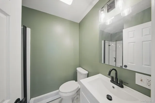 a bathroom with a sink a toilet and mirror